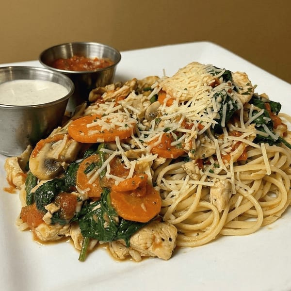 Chicken and vegetable pasta with shredded cheese, served with two dipping sauces.