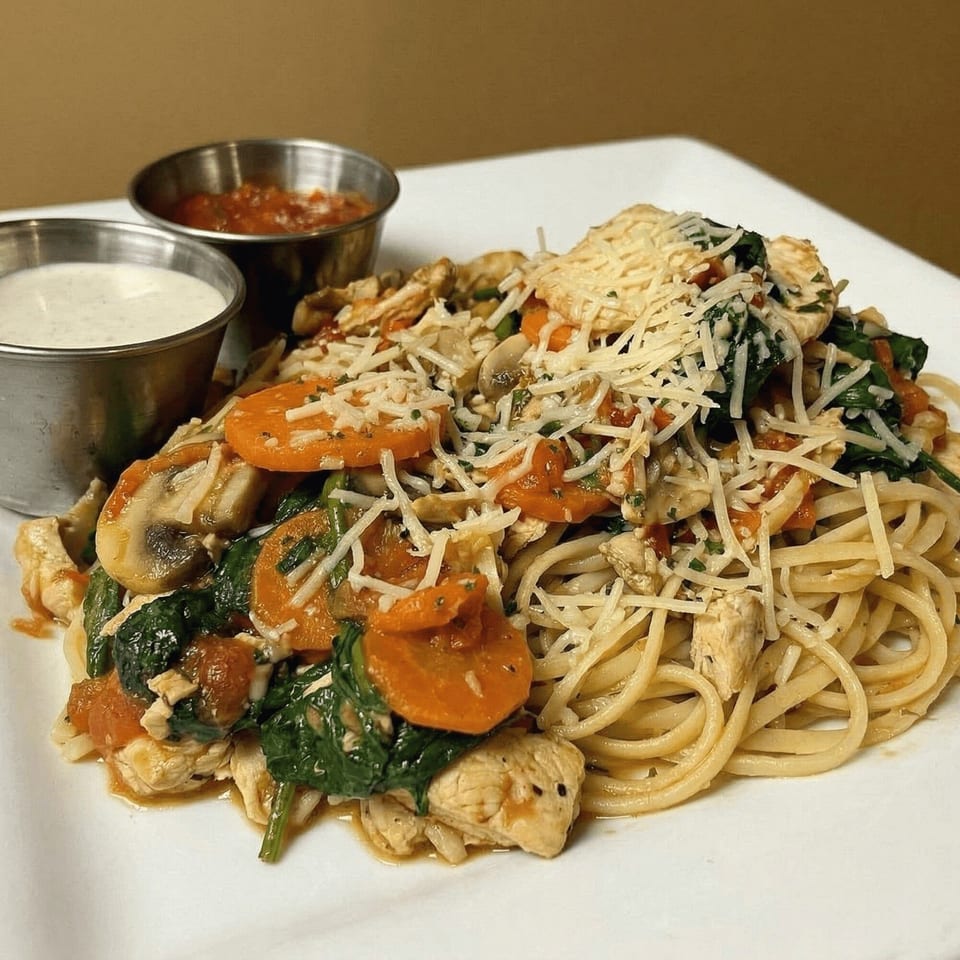 Chicken and vegetable pasta with shredded cheese, served with two dipping sauces.