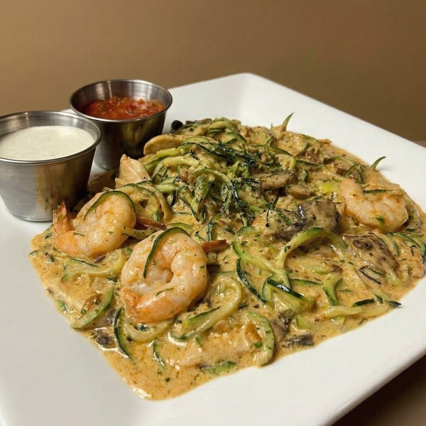 Shrimp and zucchini noodles in a creamy sauce, with sides of salsa and ranch dressing.