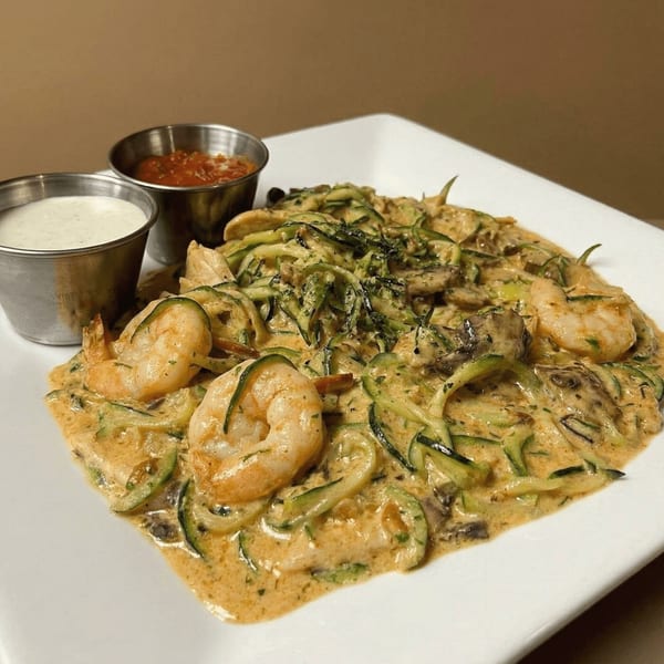 Shrimp and zucchini noodles in a creamy sauce, served with two small dipping sauces.
